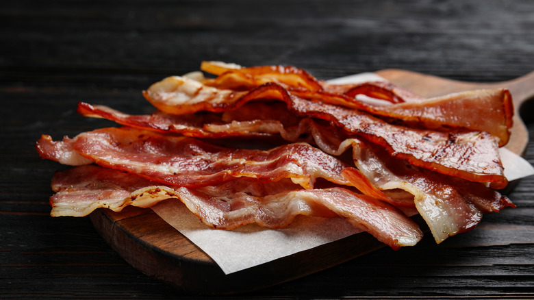 cooked bacon on wooden board