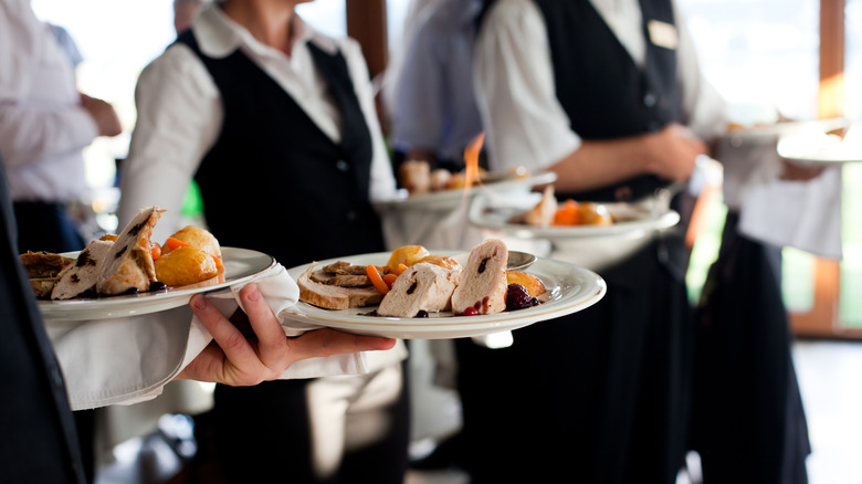 waiters carrying plates of food