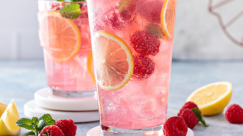 A refreshing pink mocktail with fruit and lemons inside