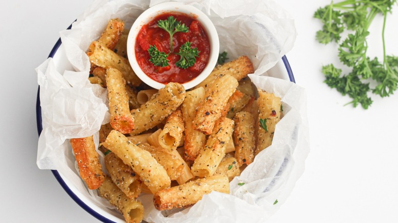 Pasta chips sitting on a platter with red sauce