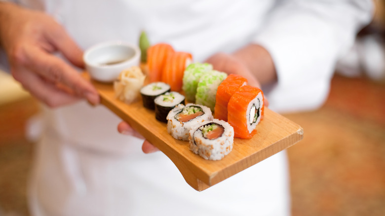 Chef holding plate of sushi