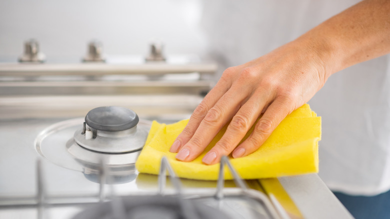 Hand cleaning stove top with sponge