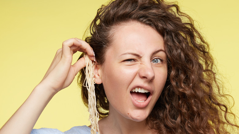 Person playing with pasta