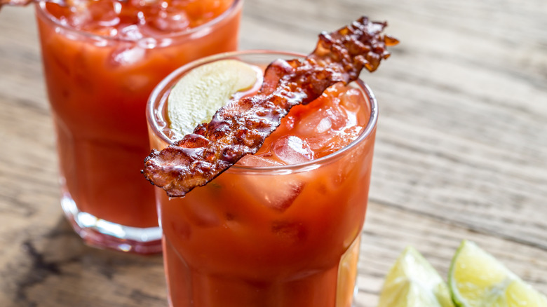 Red cocktail with bacon strips