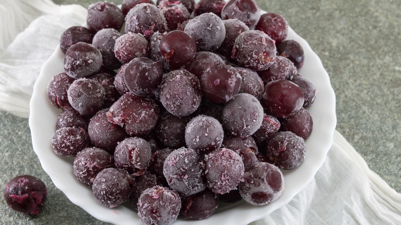 Frozen red grapes in a white bowl