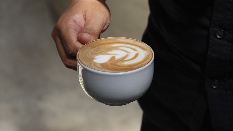 Person in black holding a latte