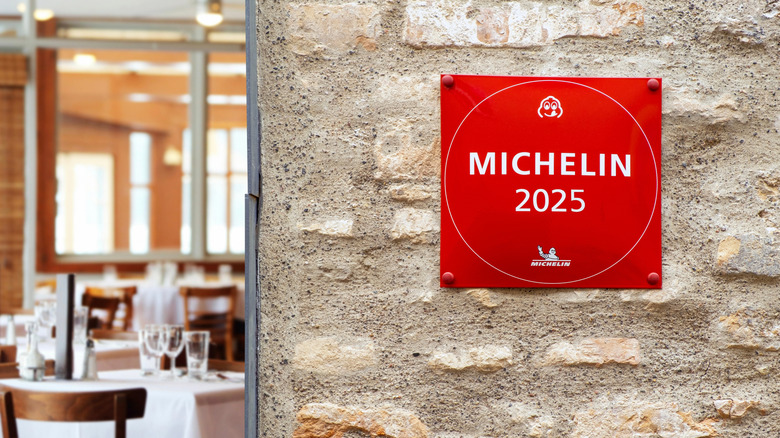 Michelin 2025 red sign attached to stone wall of restaurant