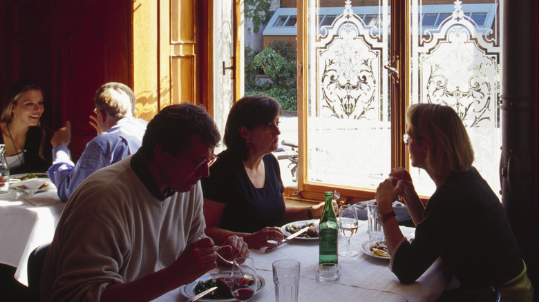 Diners at a restaurant with a bottle of water on the table