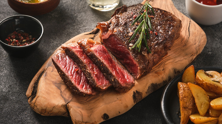 Medium rare steak on a serving board