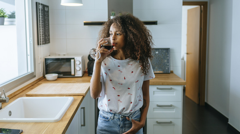 Woman drinking wine in the kitchen