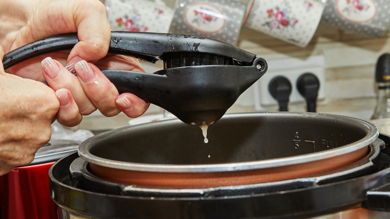 Squeezing lemon into slow cooker pot