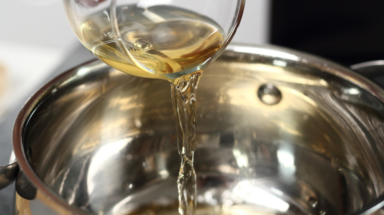 Glass of wine being poured into pan