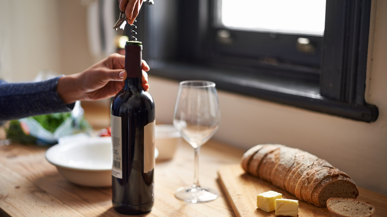 Hands opening bottle of wine