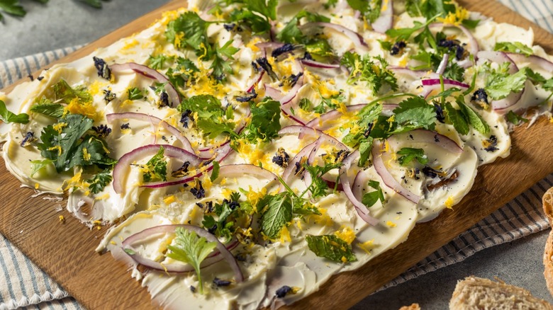 Butter board with red onions and herbs