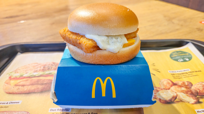 Filet-O-Fish sandwich sitting on top of a box on a tray at McDonald's restaurant.