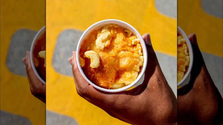Person holding small container of Chick-fil-A's mac and cheese.