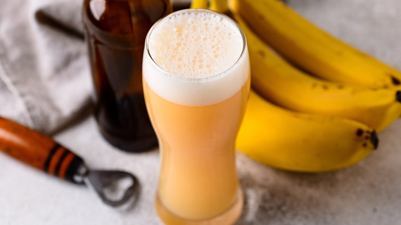 Glass of beer beside a bunch of bananas