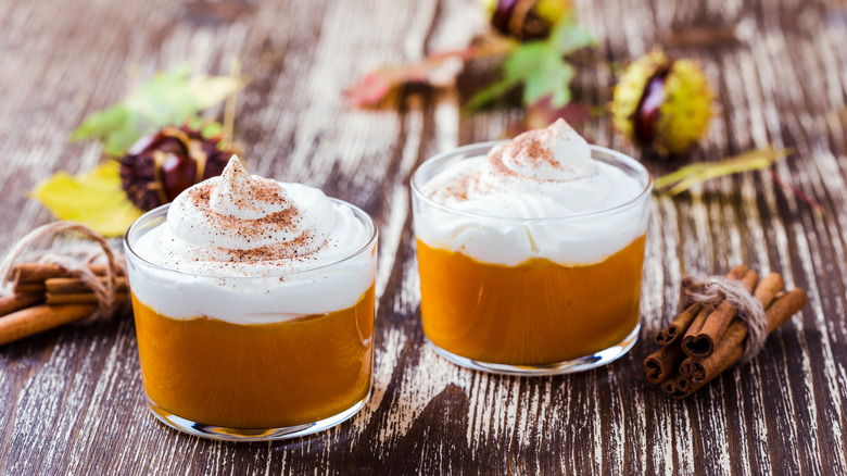 Two cups of pumpkin mousse topped with whipped cream.
