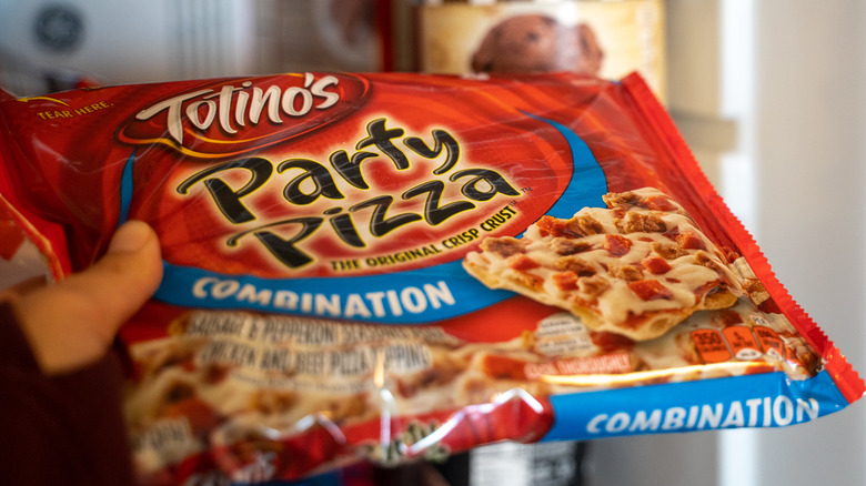 Hand holding Totino's Party Pizza packaging