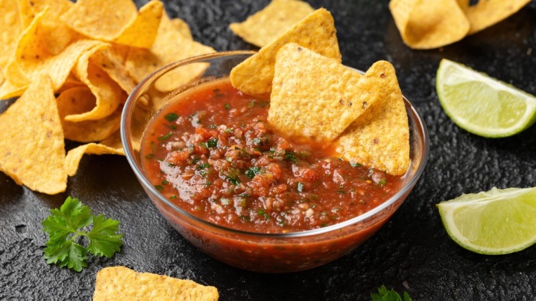Bowl of salsa with chips and line wedges
