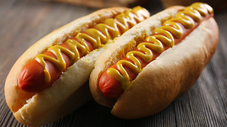 Two hot dogs with mustard