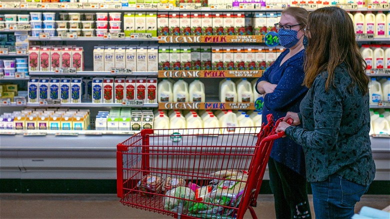 Trader Joe's shoppers with cart in dairy section 