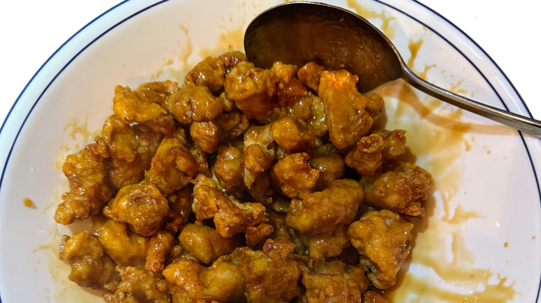 Orange chicken in a bowl with a spoon