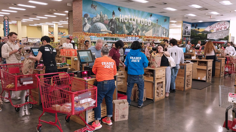 Staff and customers crowd the cash registers inside a busy Trader Joe's location.