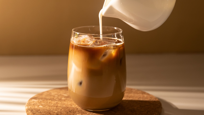 Cream getting poured into a couple of cold brew with ice