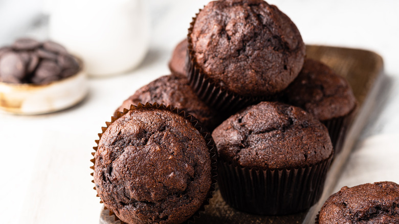 Chocolate muffins stacked on counter