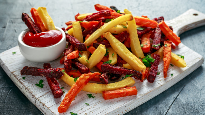 A tray of root vegetable fries with ketchup