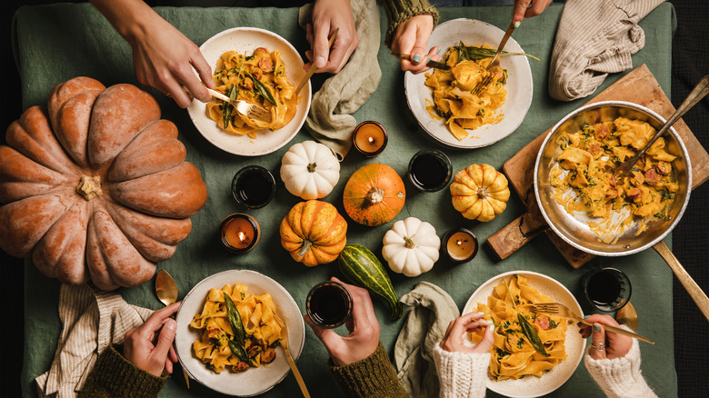 Table set with pumpkins and bowls of pasta