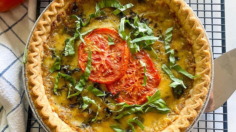 tomato pie on wire rack with chopped basil