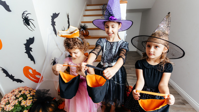 Trick-or-treaters with open candy bags