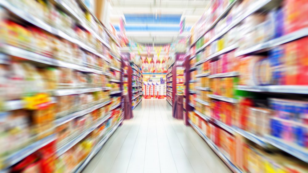 Blurred grocery store aisle full of food brands 