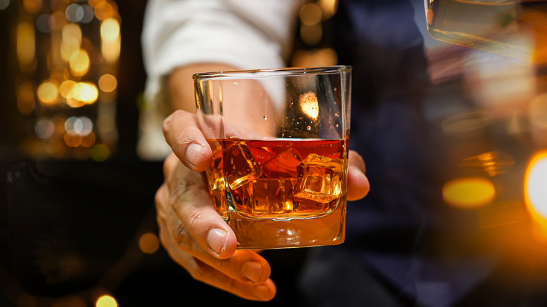 Scotch being poured into a rusty nail cocktial over ice