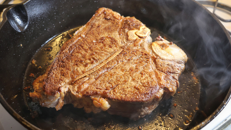 seared t-bone steak in cast iron pan