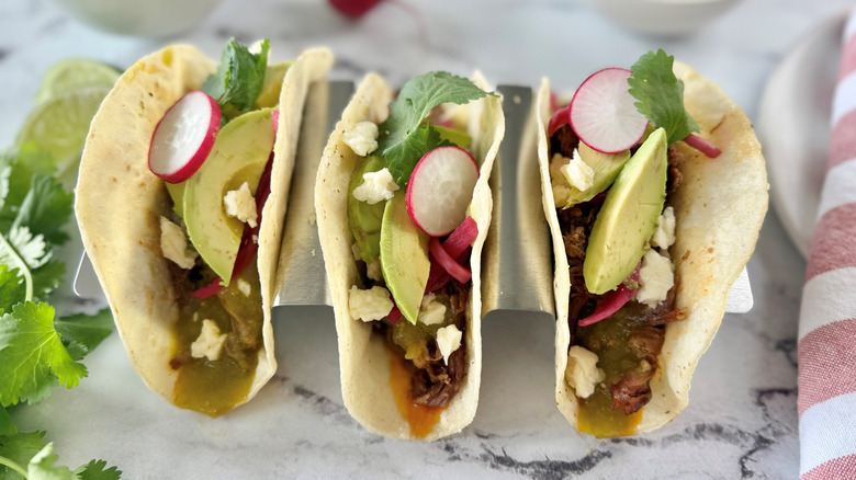Brisket tacos with various toppings in taco stand
