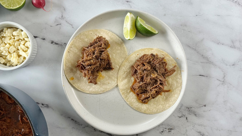 Plain brisket tacos and lime wedges on plate
