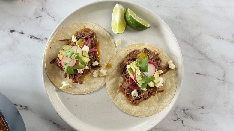 Brisket tacos with various toppings on plate