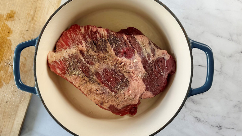 Raw, seasoned brisket in Dutch oven