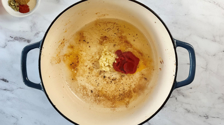 Minced garlic and tomato paste in Dutch oven