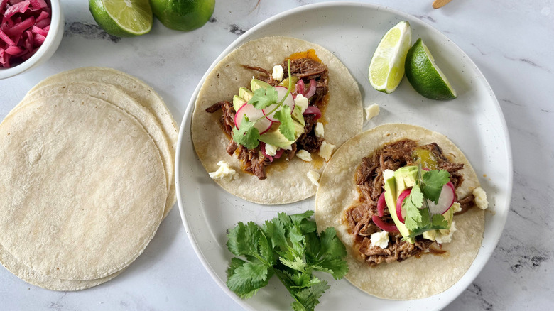 Brisket tacos with various toppings on plate