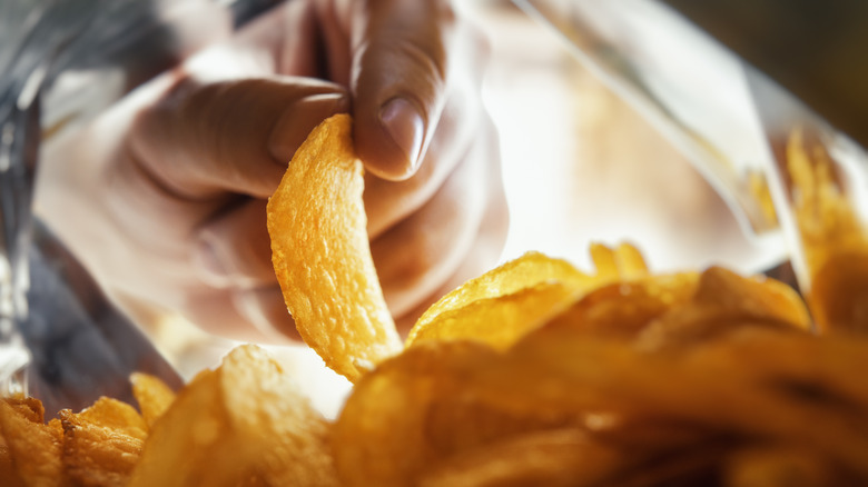 hand reaching into chip bag