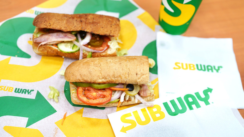 Two six-inch Subway sandwiches on a table.