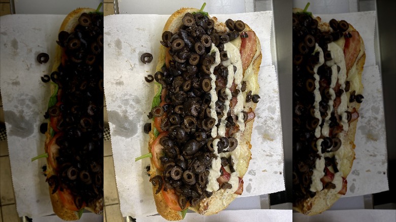 A footlong Subway sandwich with tons of black olives