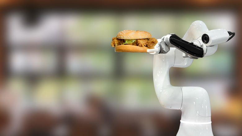 A robot holding a hamburger