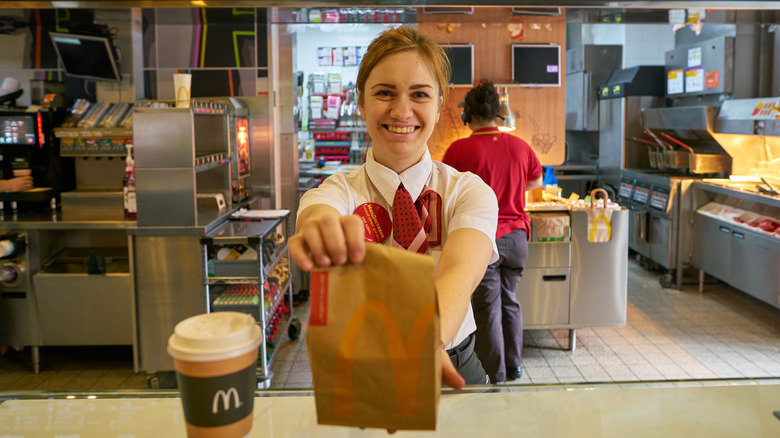 Smiling McDonald's worker with bag