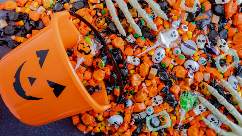 Pumpkin bucket spilling out Halloween candy