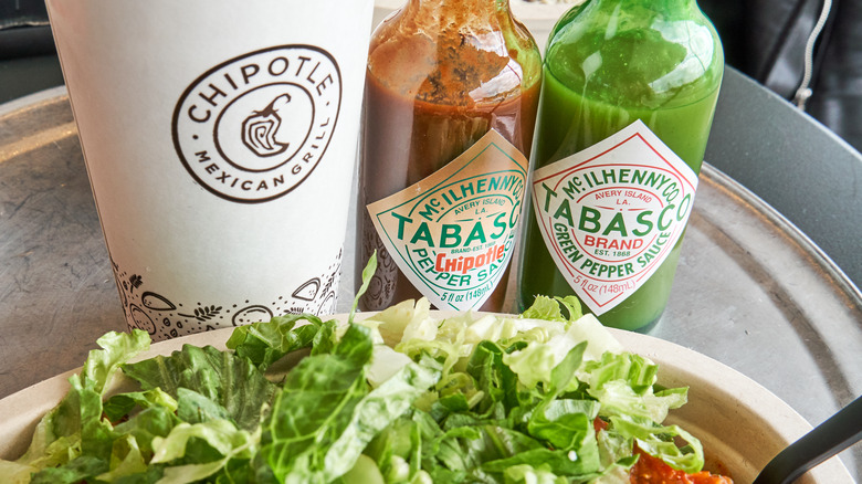 A Chipotle cup, salad, and Tabasco jars